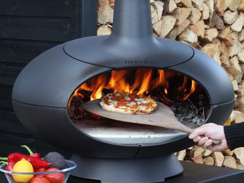 Brennender Grillofen draußen mit Pizza