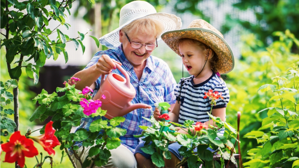Oma mit Enkelkind im Garten bei der Gartenarbeit
