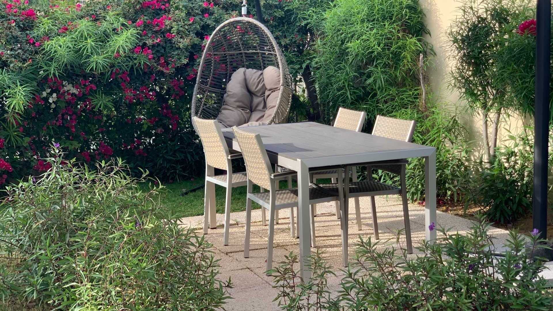 Gartenmöbel Tisch unter einem Sonnensegel mit Blick in den Garten