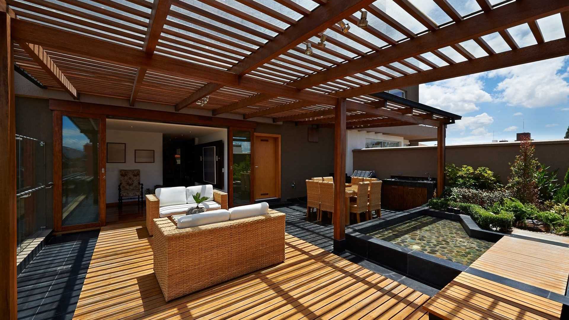 Terrassenmöbel inmitten einer wunderschönen Pergola mit Blick ins Haus.