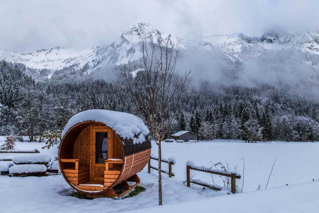 Fasssauna im Winter, Berge im Hintergrund
