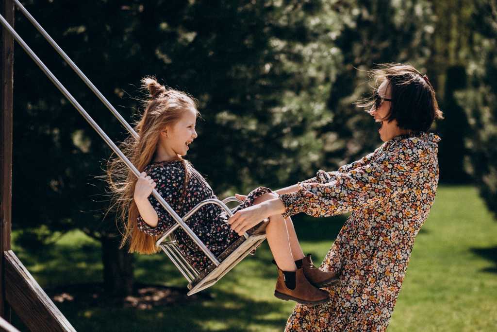 Mutter und Tochter schaukeln gemeinsam