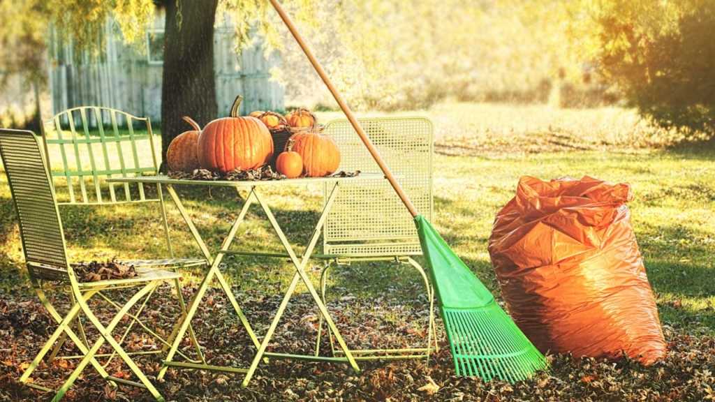 Garten mit Tisch, Stühlen und Besen