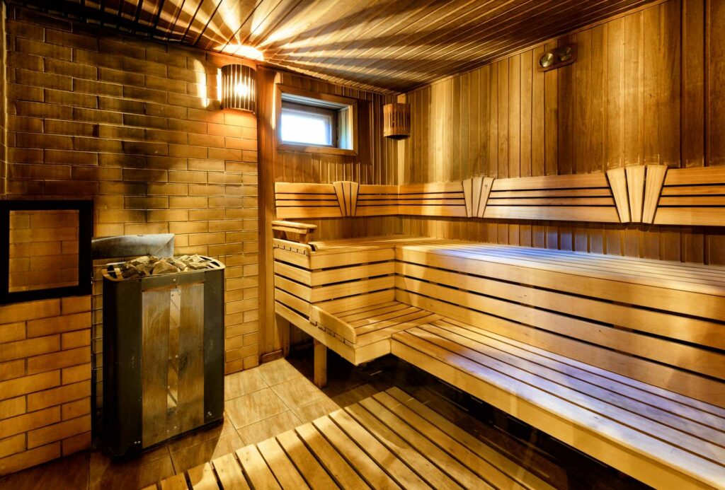 Sauna mit Backsteinwand im Inneren und Holzofen.