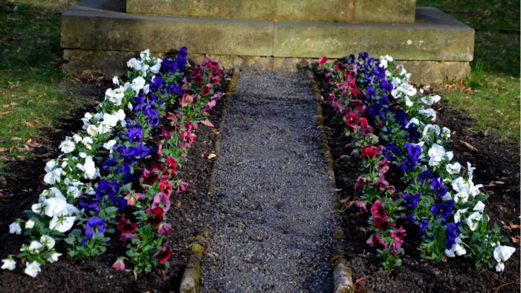 Grab mit Blumen und Steinen dekoriert