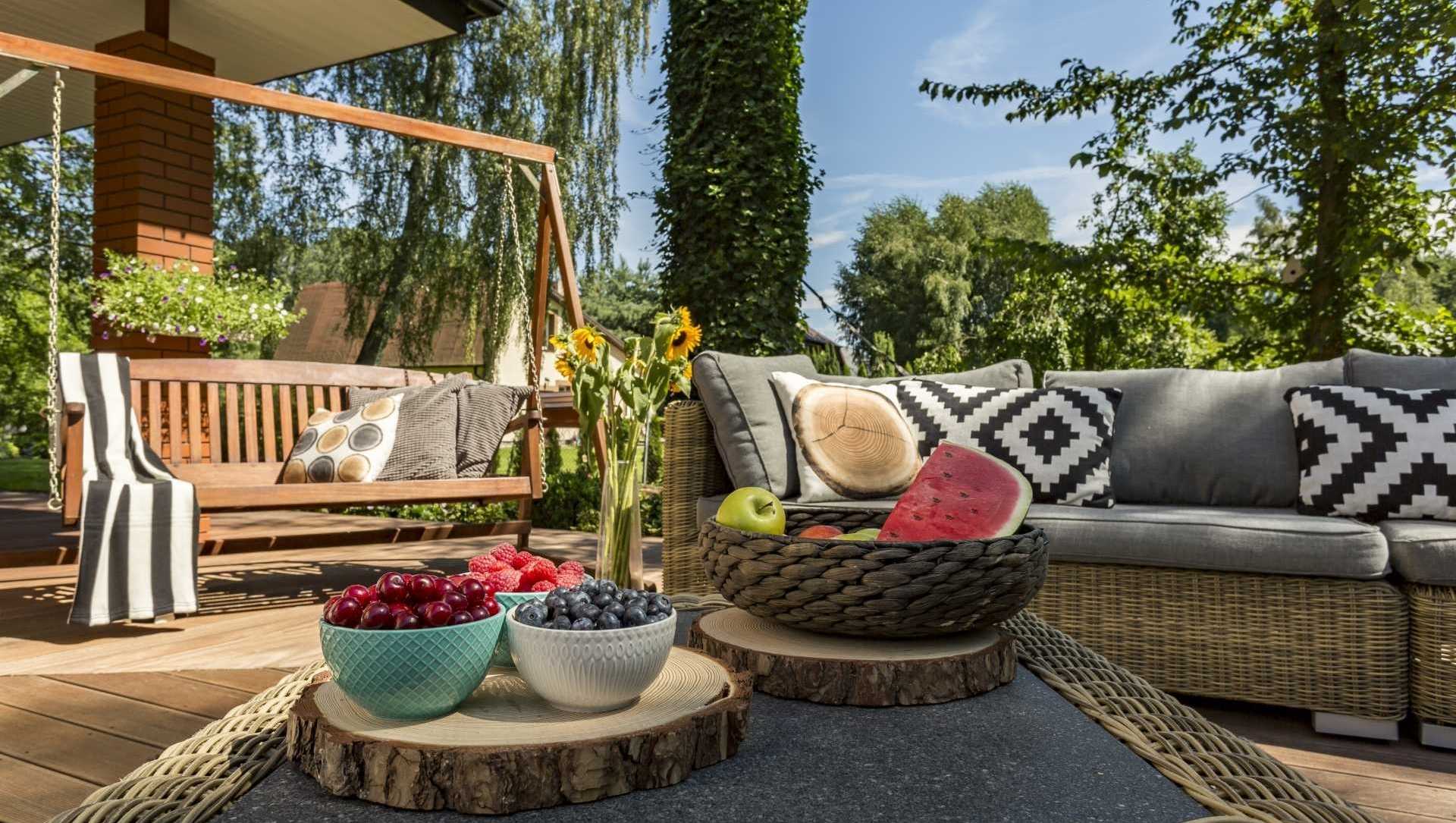 Verandaschaukel aus Holz neben Sitzgelegenheiten