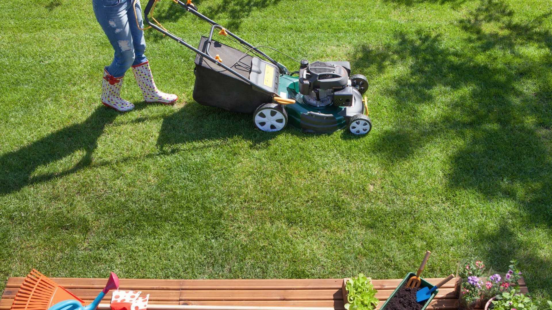 Garten wird von einer Frau gemäht